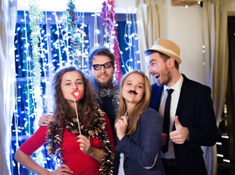 Hipster friends celebrating New Years Eve together taking photobooth pictures