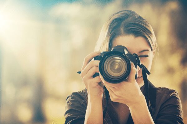 Portrait of a female photographer looking into the viewfinder of a camera