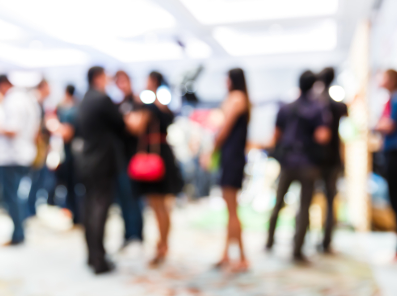 blurred co-workers conversing in press conference room